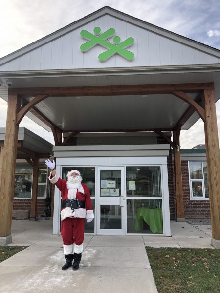 Santa Claus standing in front of the Boys and Girls Club of Kawartha Lakes building