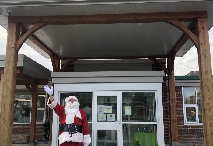 Santa Claus standing in front of the Boys and Girls Club of Kawartha Lakes building